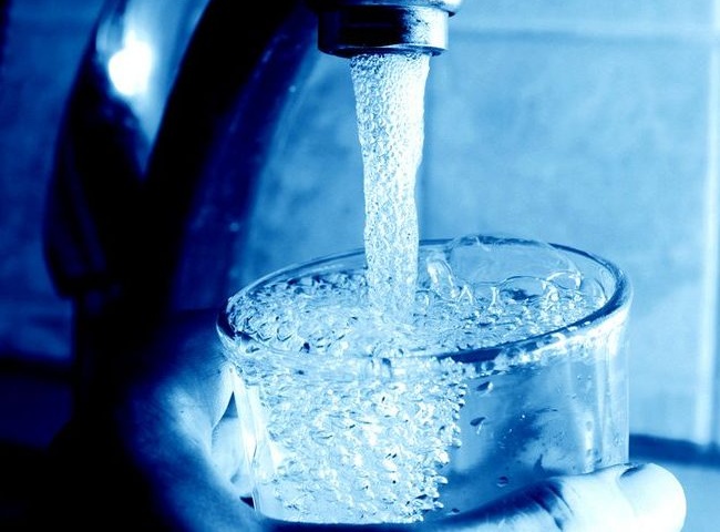 Водата тече от чешмата в чаша